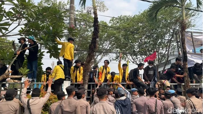 Mahasiswa ULM naik pagar dalam aksi demonstrasi di depan gedung DPRD Kalsel, Banjarmasin
